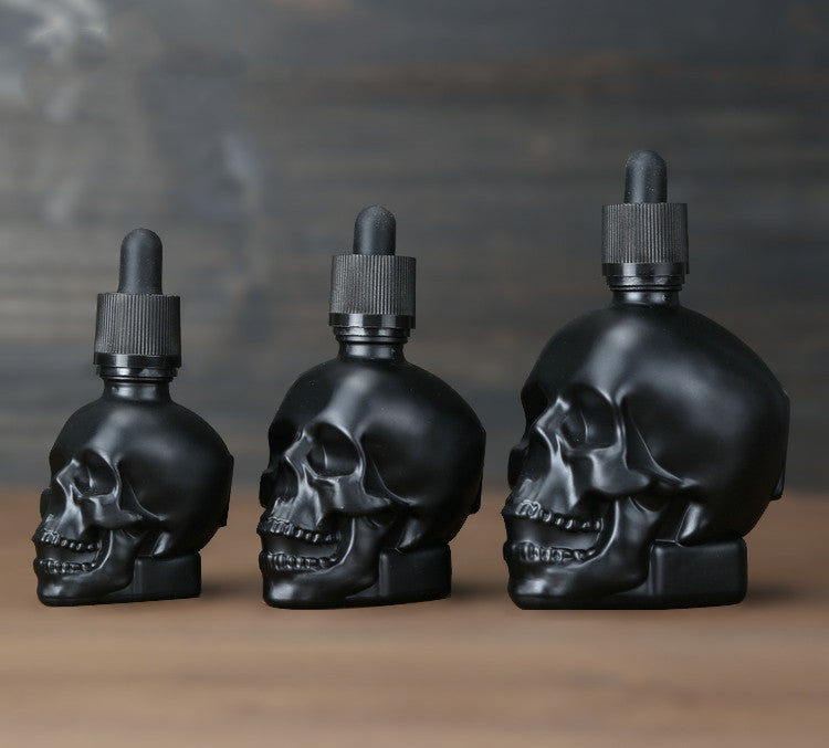 Three black skull dropper on a table.