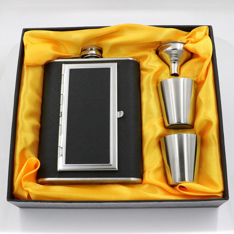 A black stainless steel whiskey flask with a cigarette compartment and two stainless steel shot glasses.